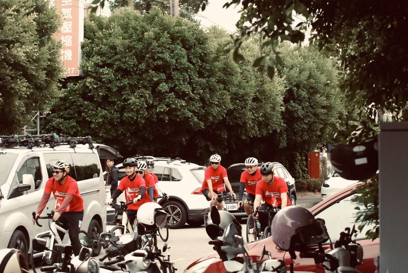車隊在分公司前集結出發，旁邊停著裝有車頂架的白色保母車