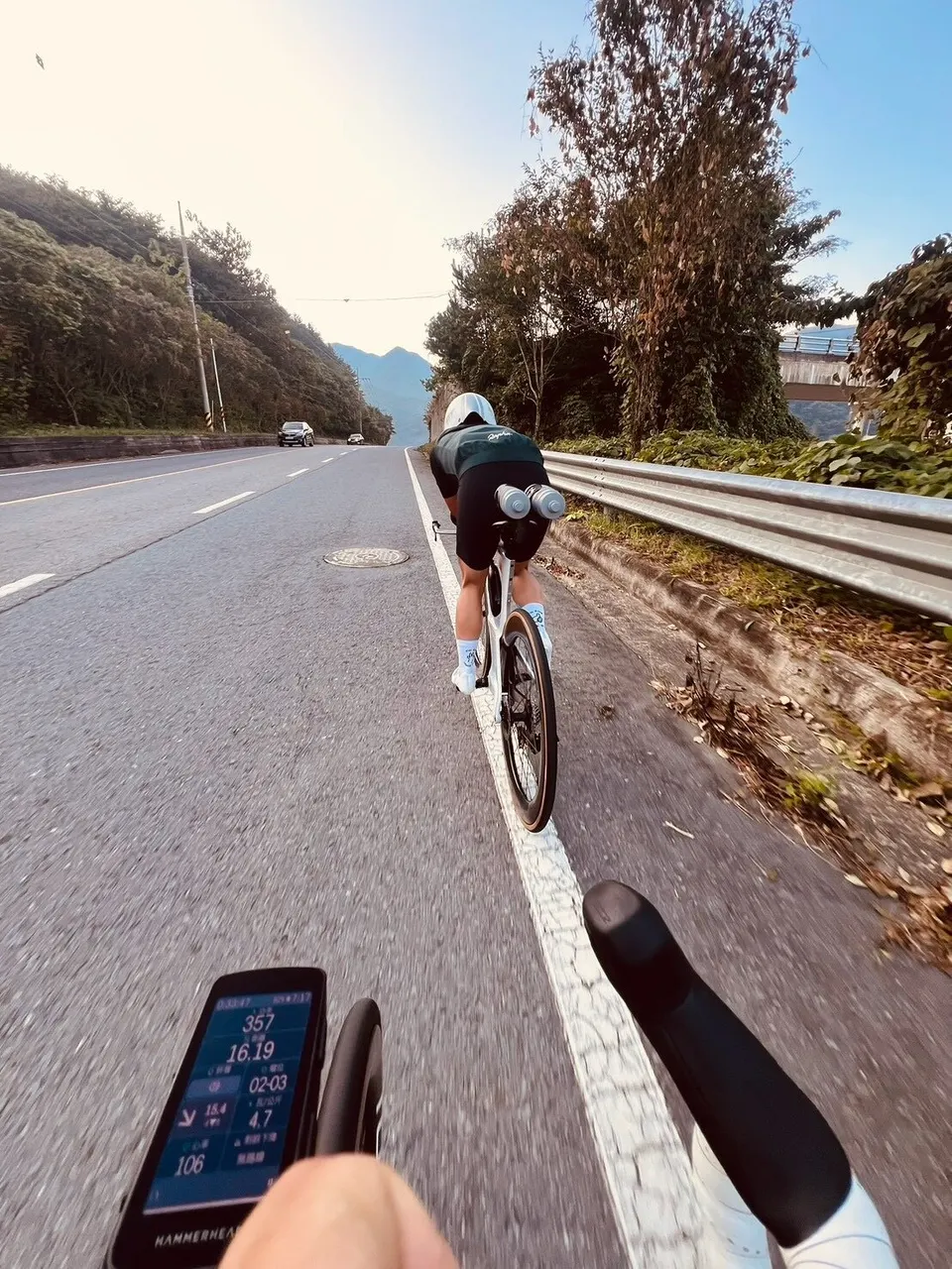 選手騎 TT 車在韓國山路路肩試騎,前方是碼表