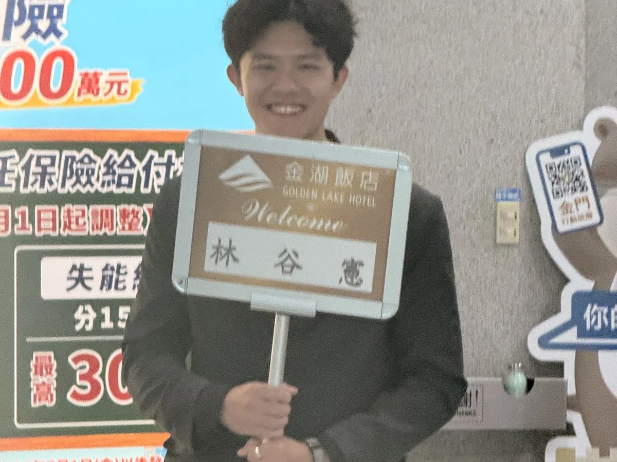 金湖飯店的接機人員在機場舉著寫有訂房人姓名的迎賓牌
