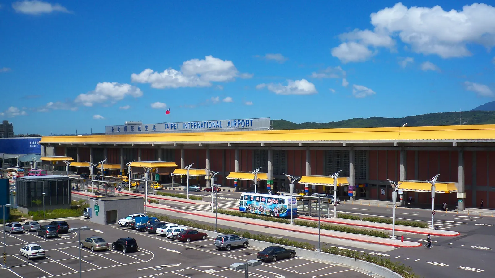 臺北國際航空站第一航廈，黃色雨庇長廊與前方停車場