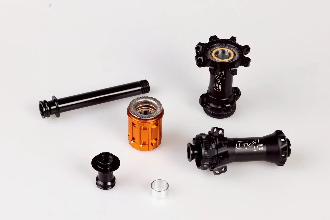 Hình tháo rời moay-ơ Salukivi G4 60T gồm trục xuyên, thân líp màu cam, nắp đầu trục, vòng đệm và hai vỏ moay-ơ