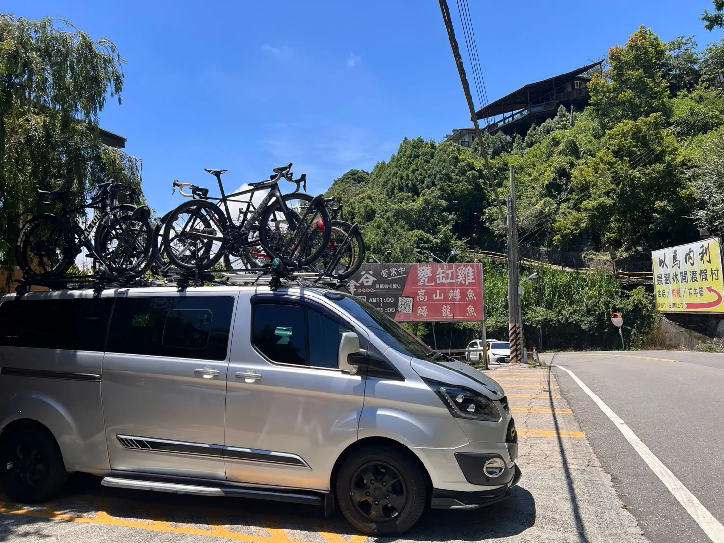 24EZGO保母車車頂載運多台公路車，停靠在武嶺行程的在地餐廳旁